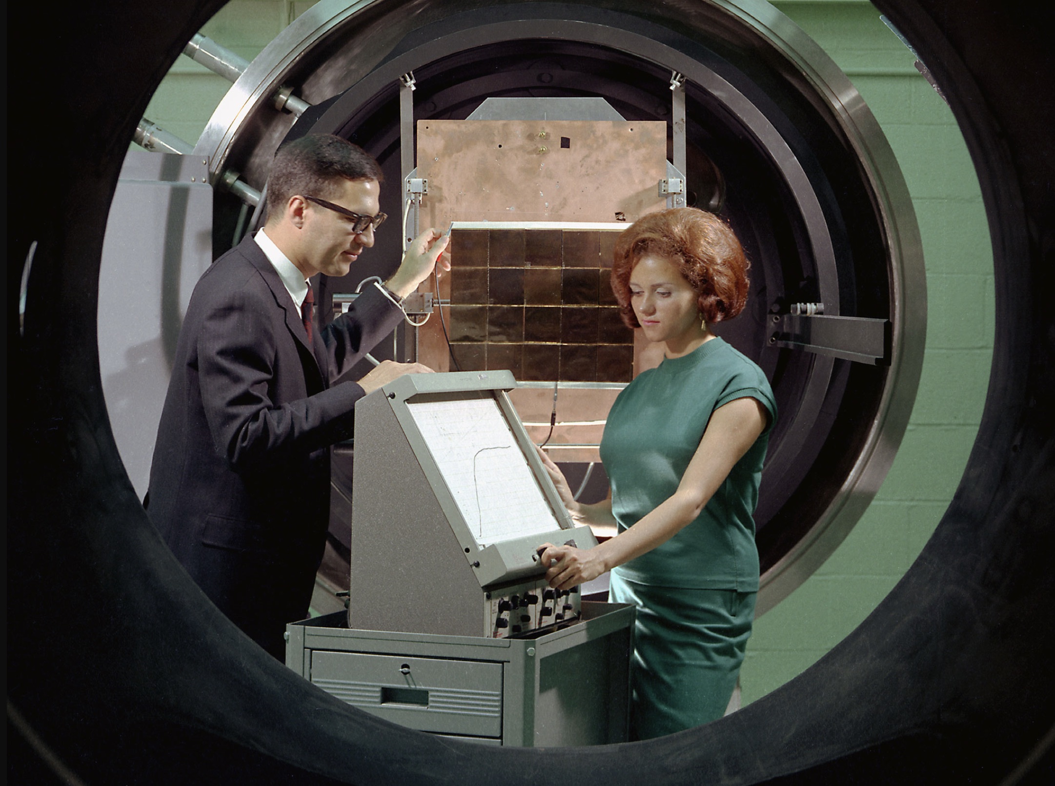 George Mazaris, works with an assistant to obtain the preliminary measurements of cadmium sulfide thin-film solar cells being tested in the Space Environmental Chamber 